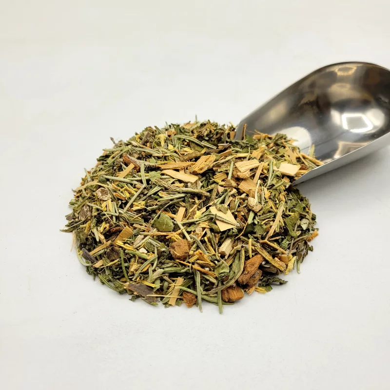 Tisane bio Hépato Détox montrant le mélange de plantes médicinales et une pelle à thé pour le nettoyage du foie et de l'organisme.