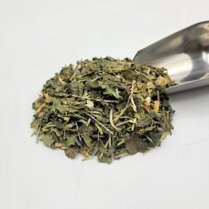 Tisane bio pour peau nette, montrant les plantes médicinales et une petite pelle à thé.
