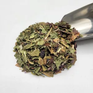 Mélange de plantes médicinales bio pour tisane de drainage formule Docteur Sammut avec une pelle à thé.